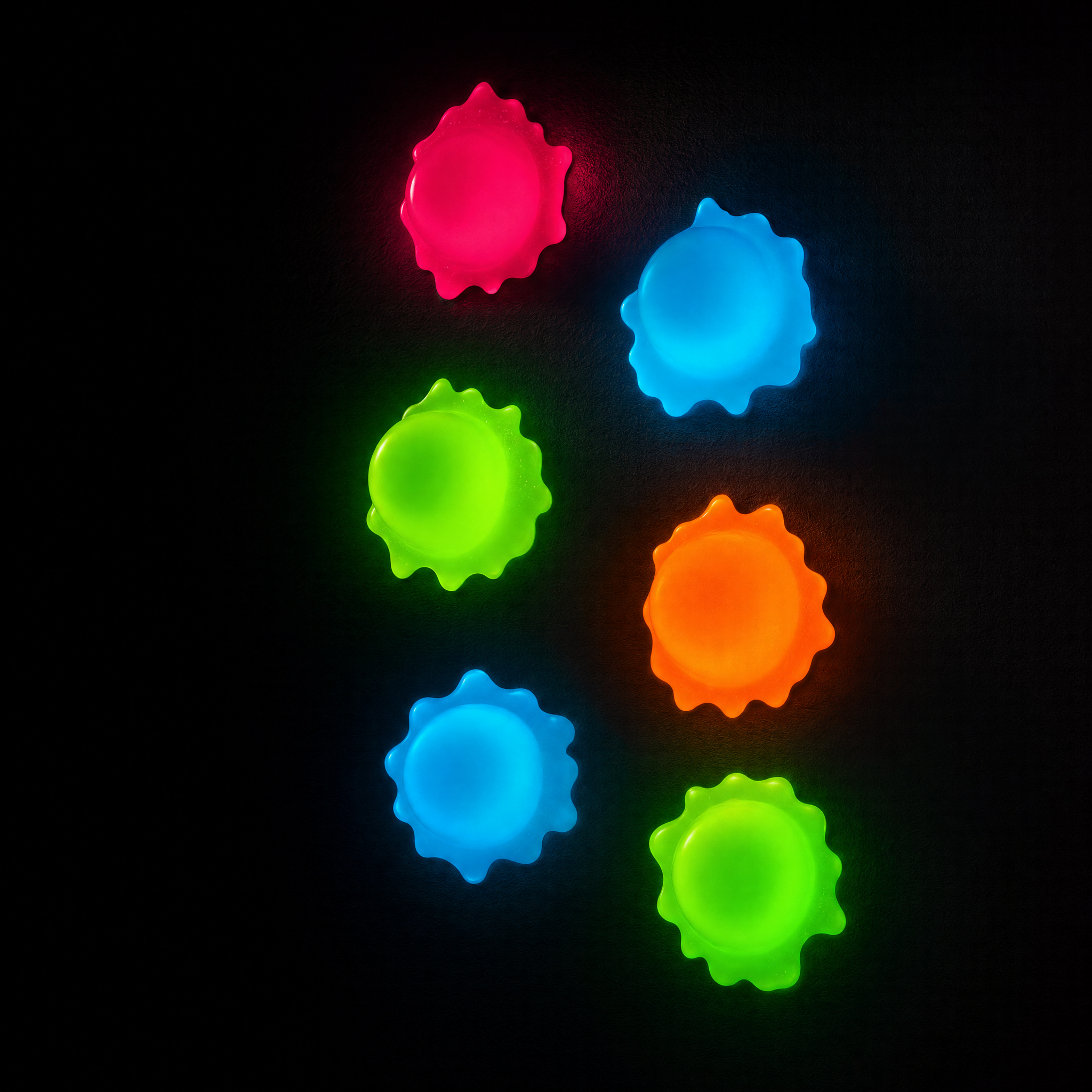 BB Balls glow-in-the-dark sticky wall balls glowing neon on a dark wall — brand lifestyle shot